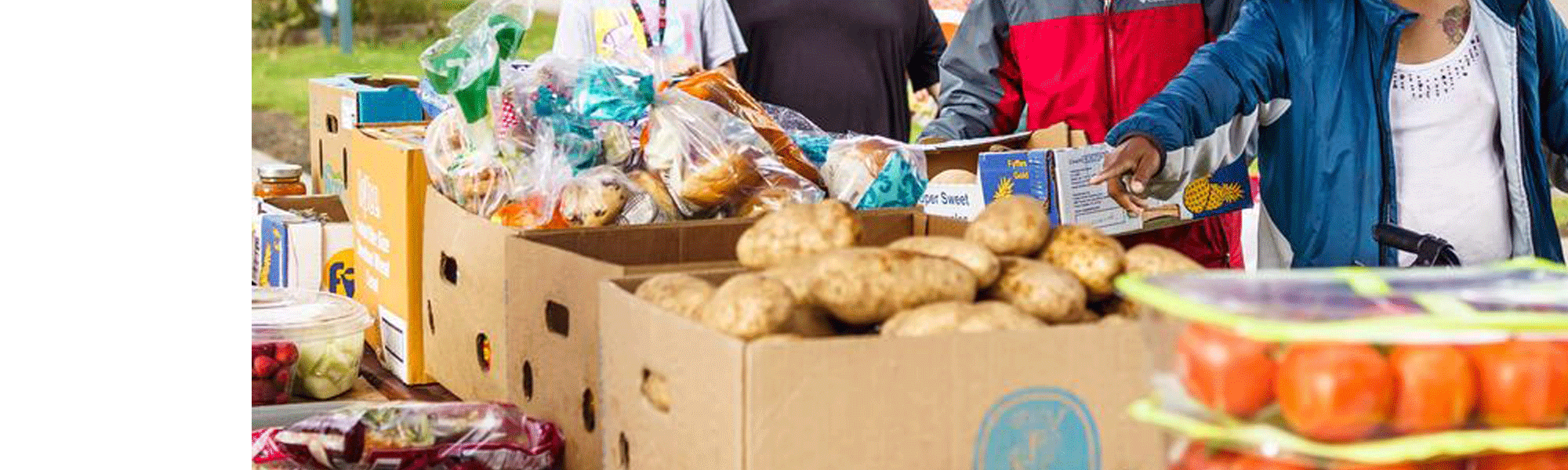 Line of people picking up produce.