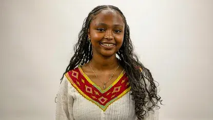 A portrait of a black teenager in a white dress with red trim.